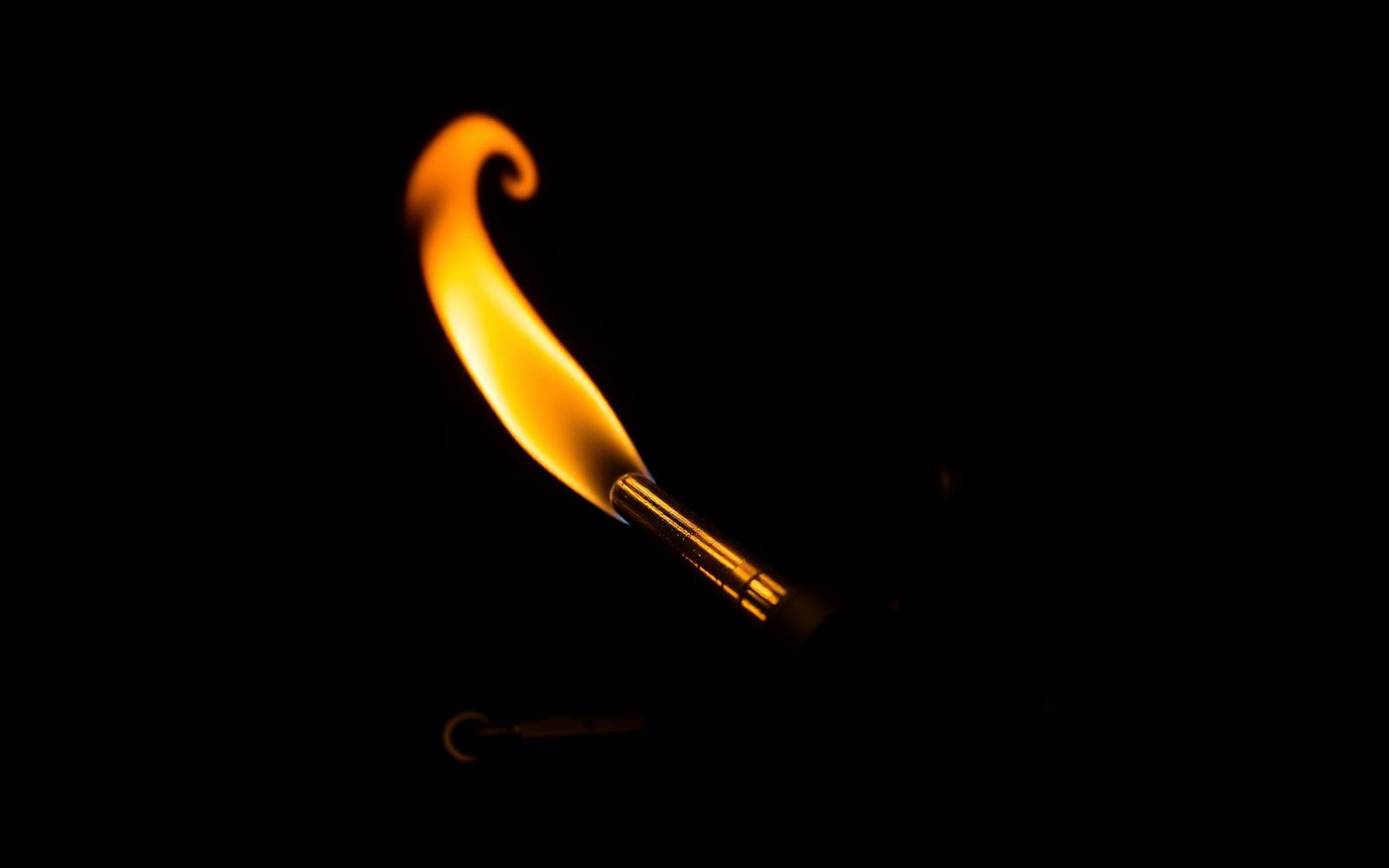 Torch flame shaping a borosilicate glass rod at the Salem studio bench